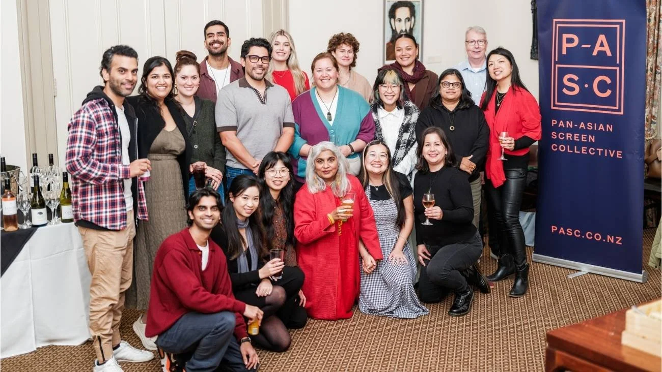 Participants in "Episode One: The Redux", a year-long web-series development and pilot production programme run by Shuchi Kothari for PASC, smile, standing next to a PASC pull-up banner.