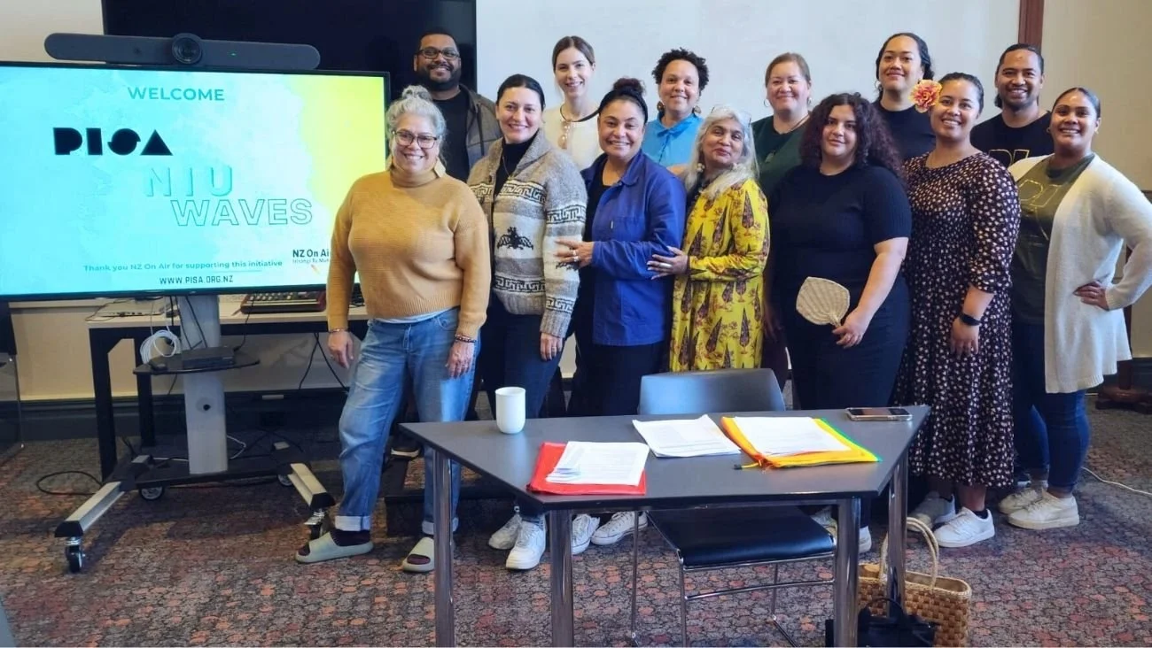NIU Waves: Series Development (PISA – Pacific Islanders in Screen Arts, 2024 participants standing together in a conference room, smiling for a photo in front of a large display screen with a welcome message for PISA NW WAVES initiative.