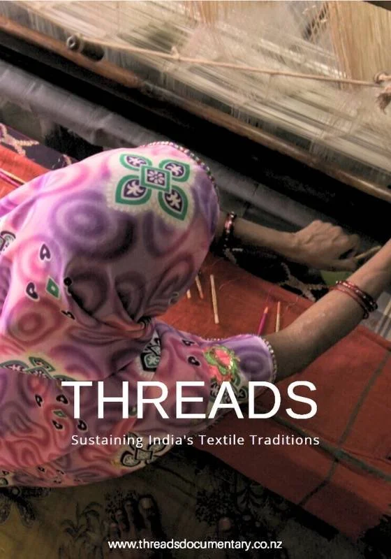 Poster for documentary 'Threads'. Close-up of a woman in a pink patterned sari working on a traditional handloom weaving textile.