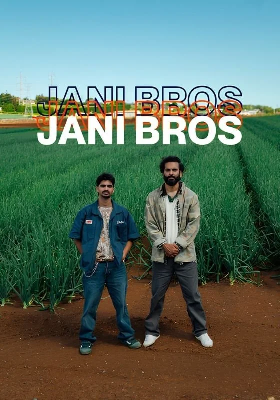 Poster for web series 'Jani Bros'. Two men standing in a green field of crops with a clear blue sky in the background and large text above them that reads 'JANI BROS'.