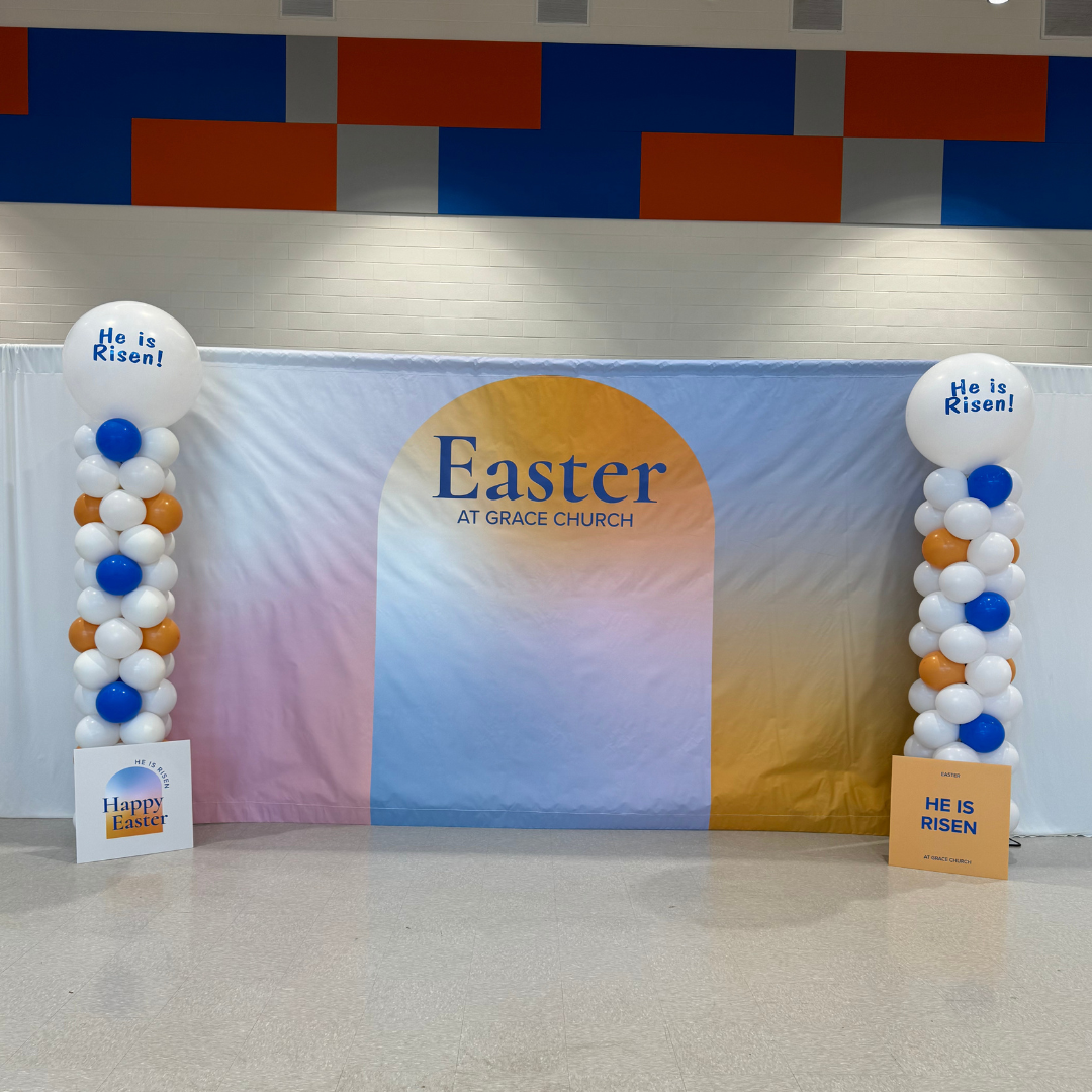 Easter celebration setup at Grace Church with balloons and banners featuring religious messages and festive colors.