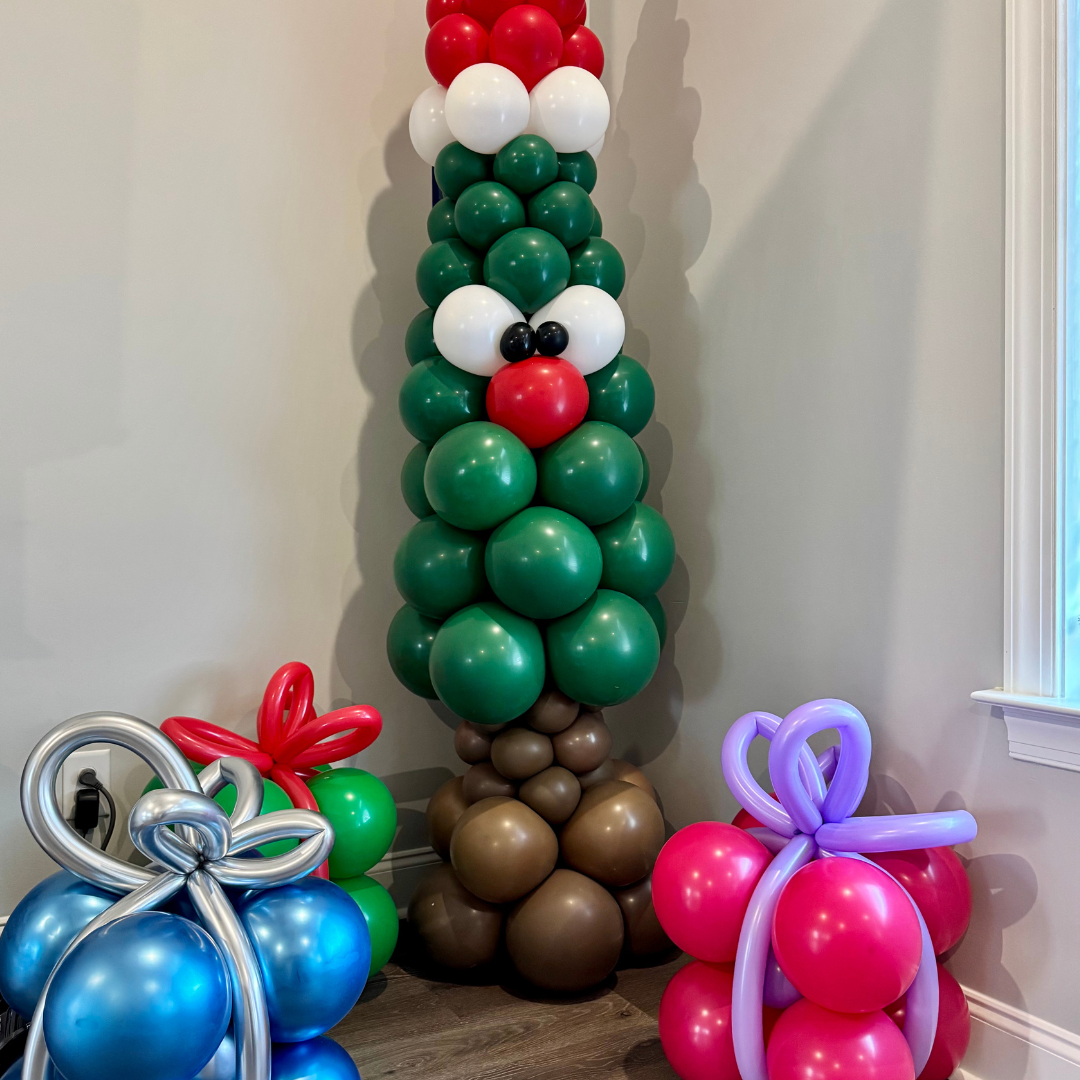 Colorful balloon decorations resembling a Christmas tree with presents made of balloons at the base.