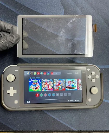 A Nintendo Switch console with a detached screen and a game display on the main screen. The main screen shows a selection of Sonic the Hedgehog games, and the detached screen appears to be a protective cover or additional display.