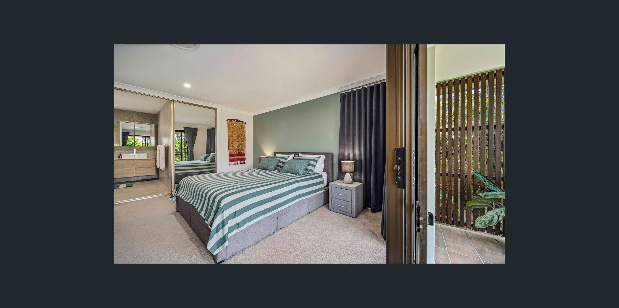 Modern bedroom with bed, nightstand, and sliding glass door leading to a balcony or outdoor area.