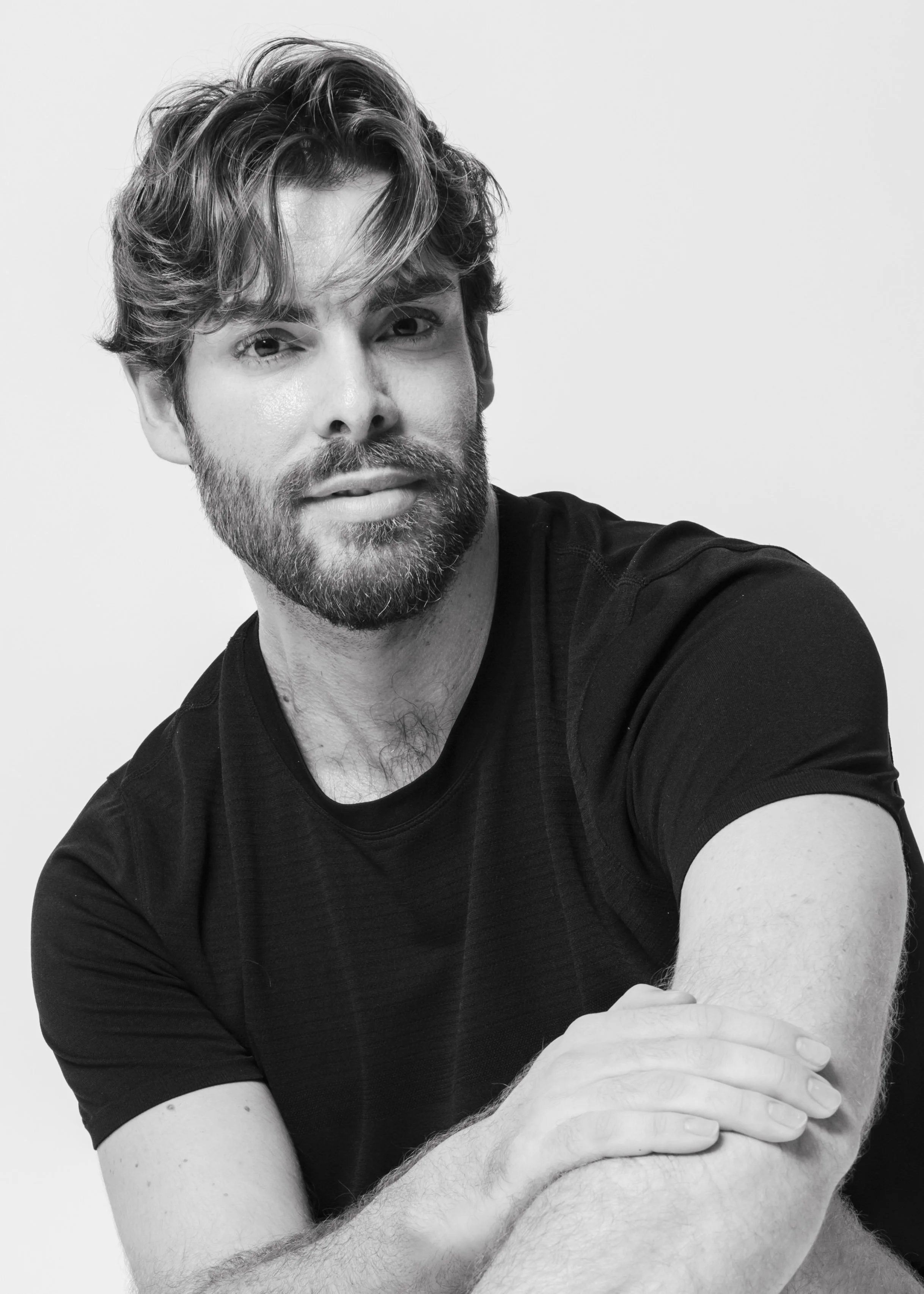Black-and-white portrait of Darío Almenara seated in a black T-shirt.