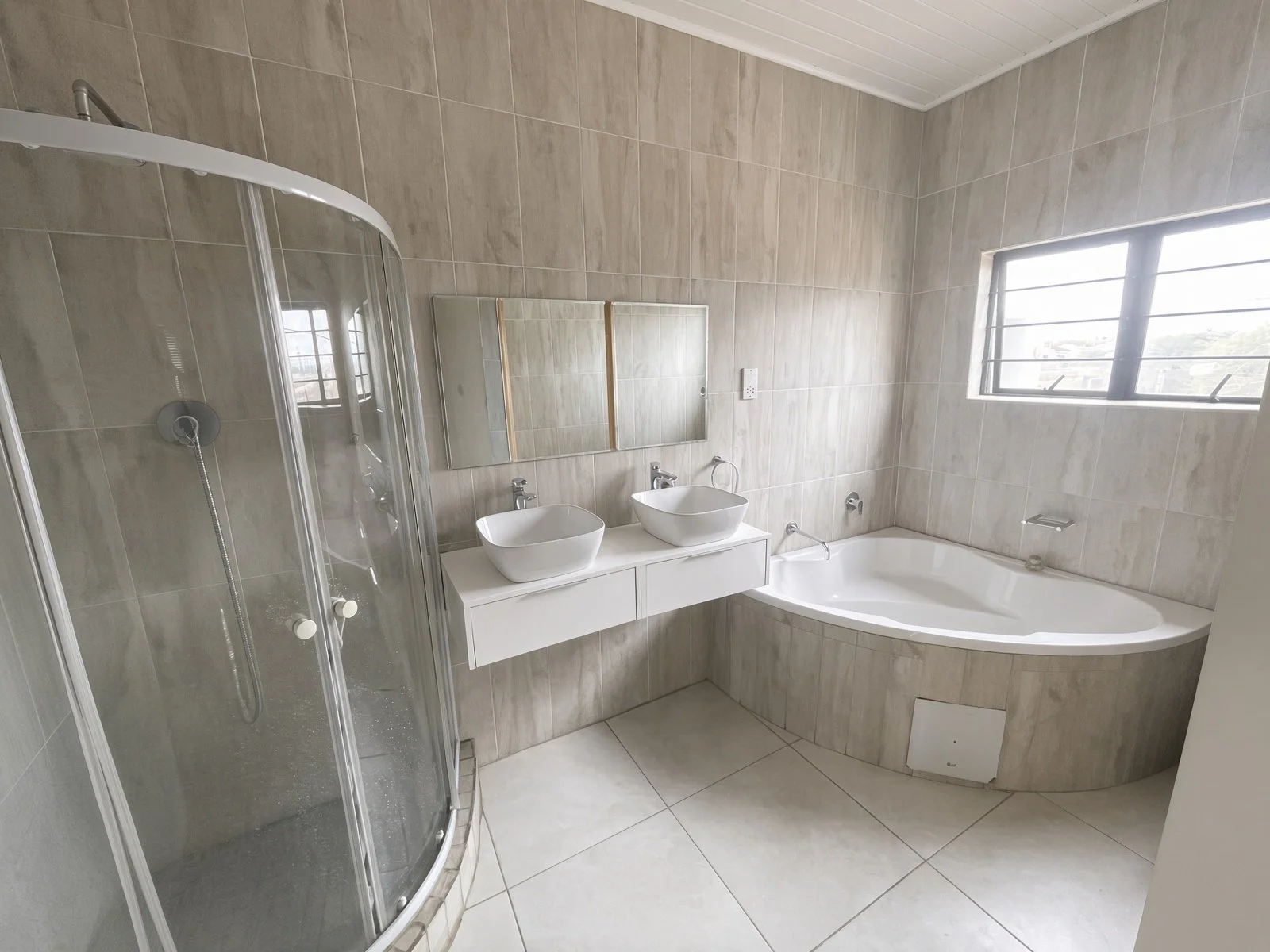 Modern Master ensuite bathroom with curved glass shower, double vessel basins and corner bath, Gaborone house for sale