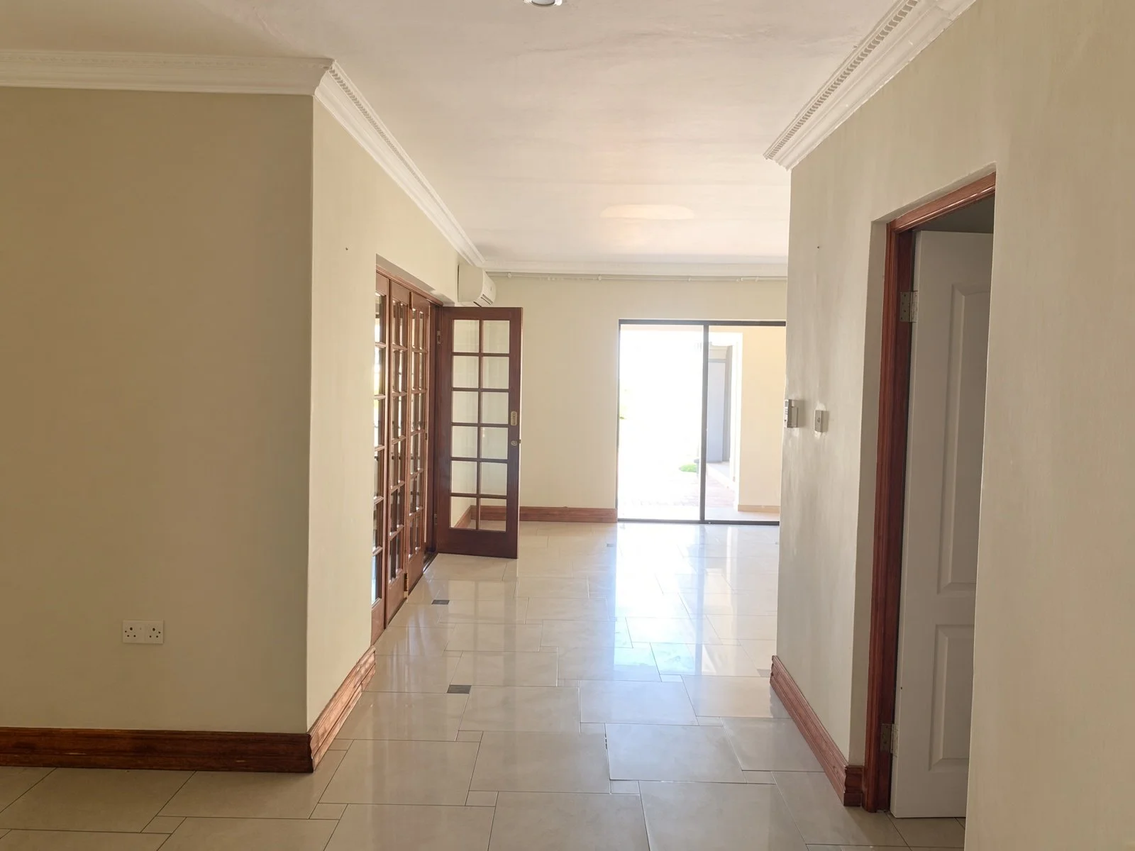 Passage leading to sliding doors and the patio in a Phakalane house for rent