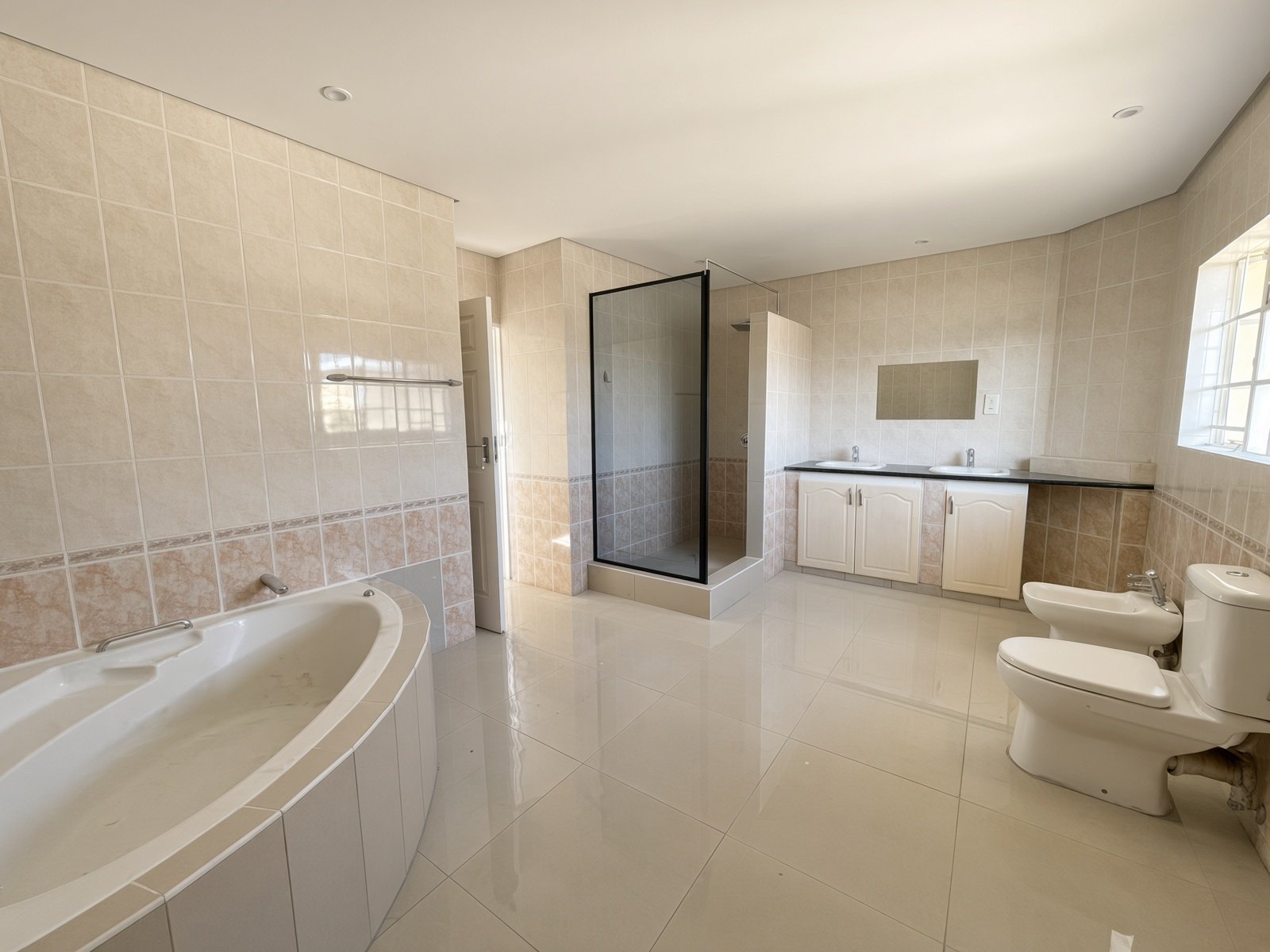 Master ensuite with bathtub, glass shower, double basins and bidet in a house for rent in Block 9 Gaborone
