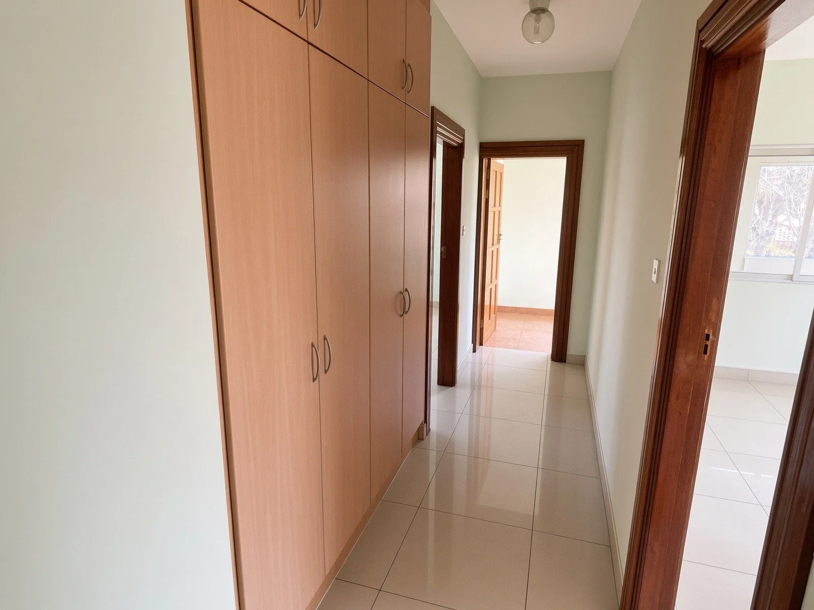 Internal hallway with built-in storage and wooden door frames in the 4-bedroom house for rent in a secure gated estate, Phakalane. Nestgeeks.