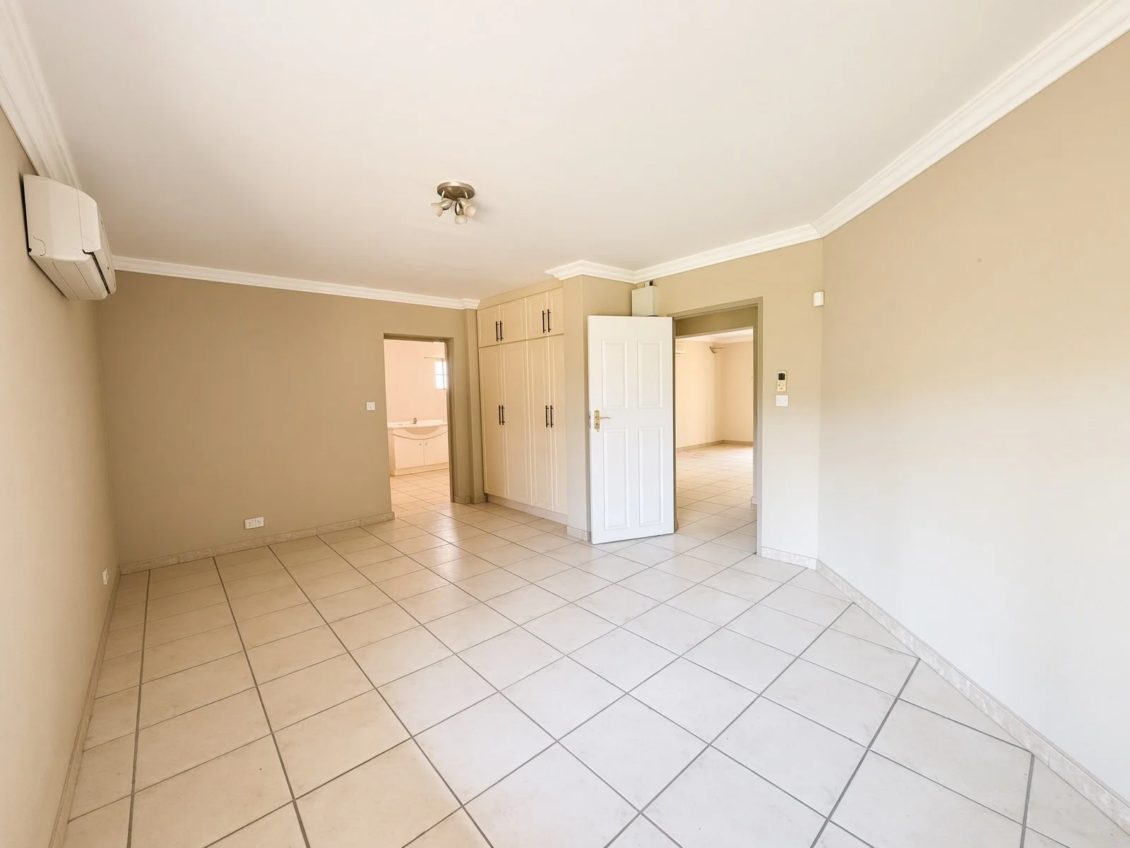 Bedroom with built-in wardrobe and open doors in a 5-bedroom Phakalane home for sale