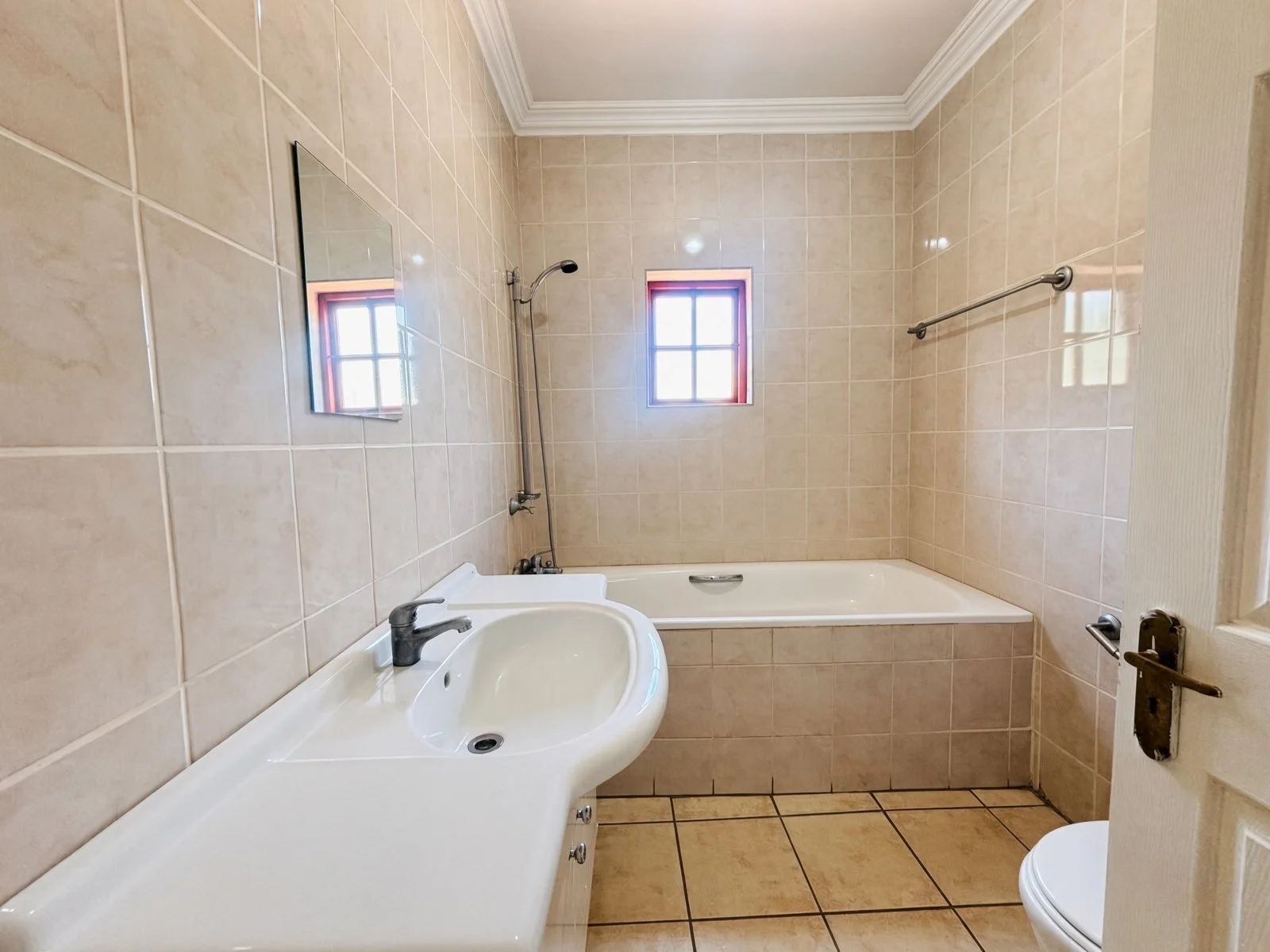 Bathroom with bathtub, basin and toilet in a house for sale in Phakalane Golf Estate