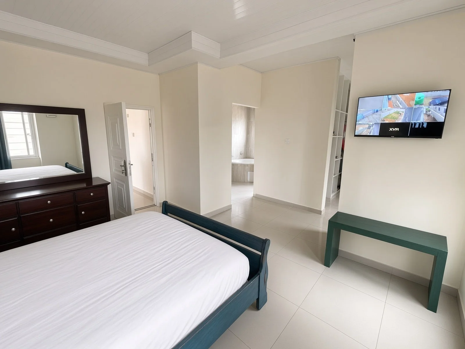 Spacious master bedroom with ensuite access, dresser and security camera display, house for sale Gaborone