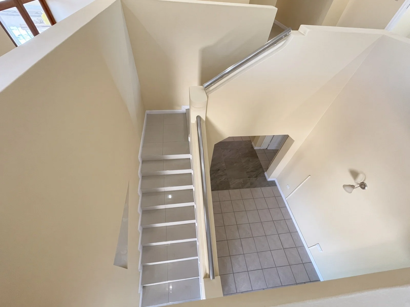 Tiled staircase with stainless steel handrail in a 5-bedroom family home for rent in Block 9 Gaborone