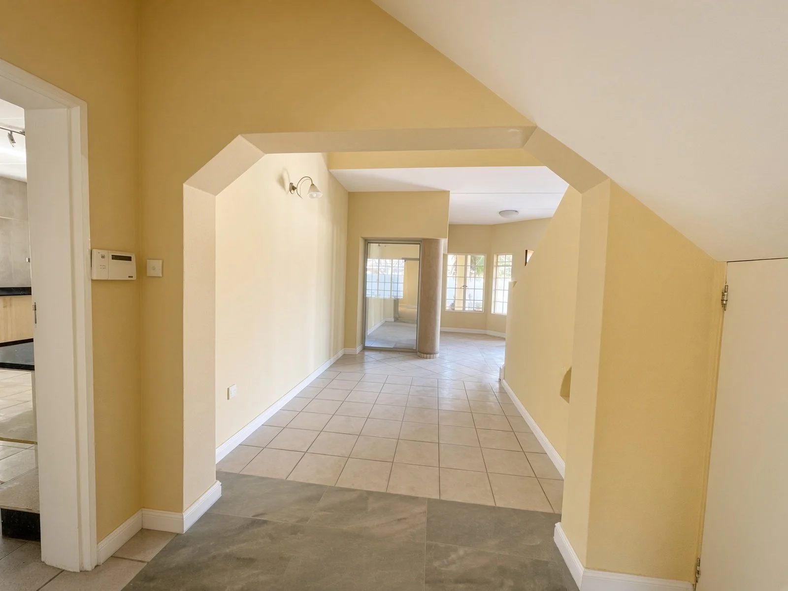 Arched hallway leading to a bright living area in a 5-bedroom house for rent in Block 9 Gaborone