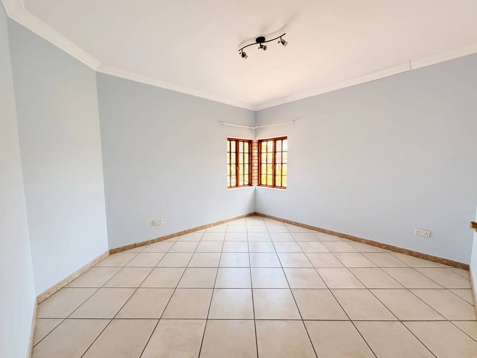 Corner bedroom with wooden windows in a 5-bedroom house for sale in Phakalane