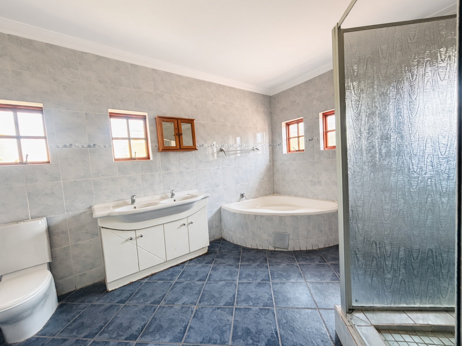 Bathroom with corner bathtub, double vanity and glass shower in a Phakalane house for sale
