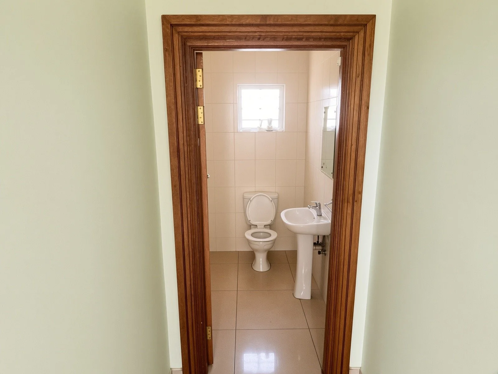 Guest toilet with basin and tiled walls in the 4-bedroom house for rent in a secure gated estate, Phakalane. Nestgeeks.