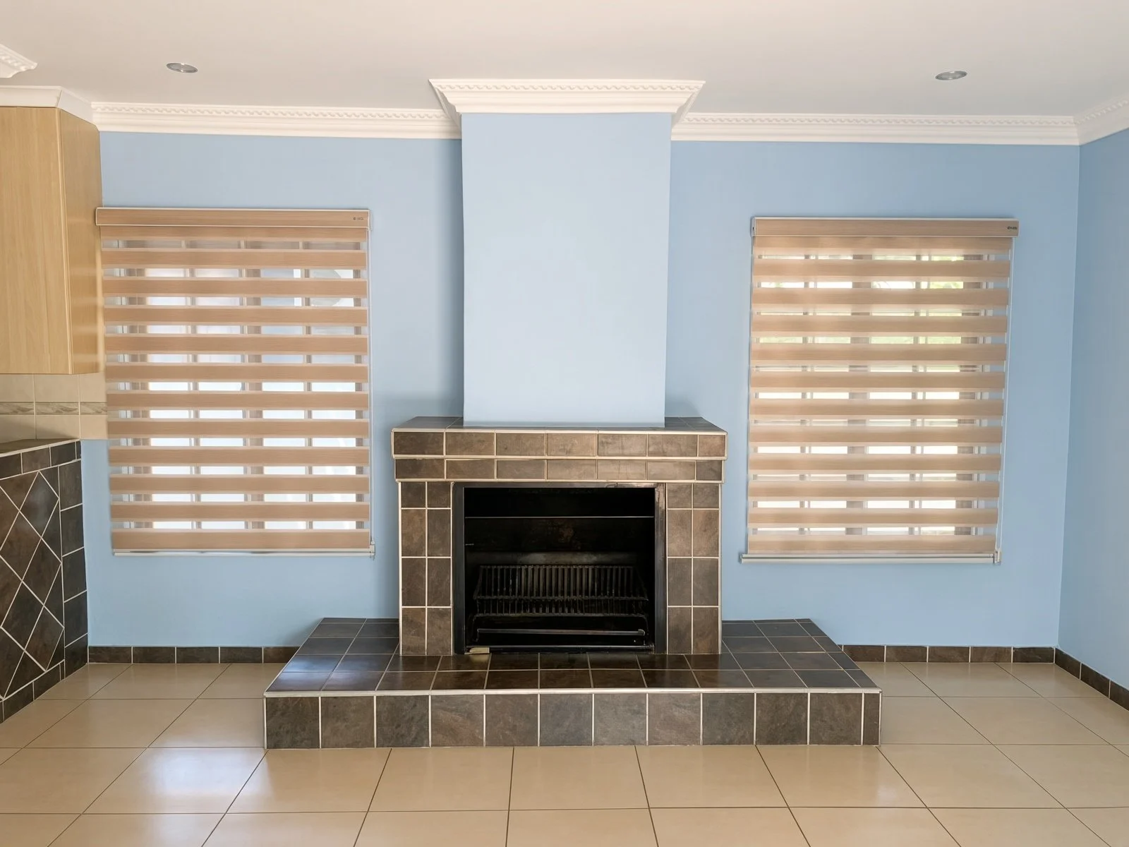 Tiled fireplace with raised hearth in the lounge of a 4-bedroom house for rent in Phakalane