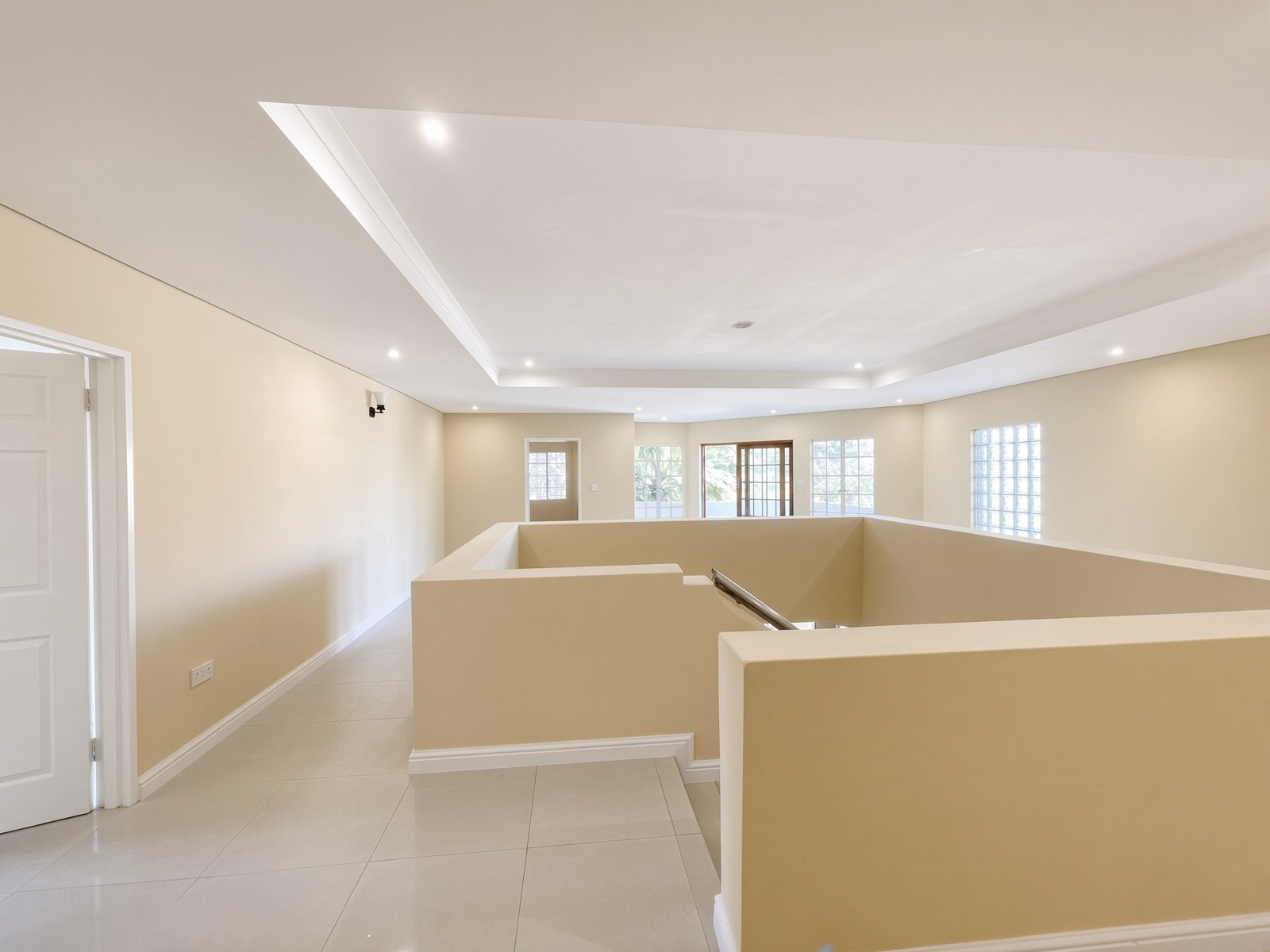 Upstairs landing with recessed ceiling lights and glass-block windows in a Block 9 Gaborone house for rent