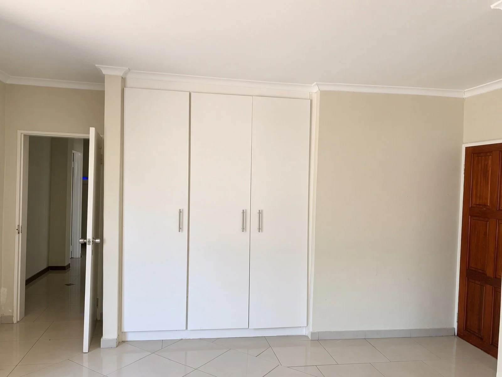 Floor-to-ceiling white built-in cupboards in a hallway of a Phakalane house for rent