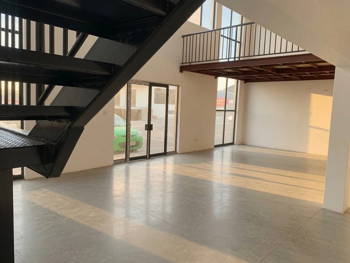 Black metal staircase and view to parking area in double-storey commercial property, ideal for retail, spa, offices, workshop or restaurant now for sale.