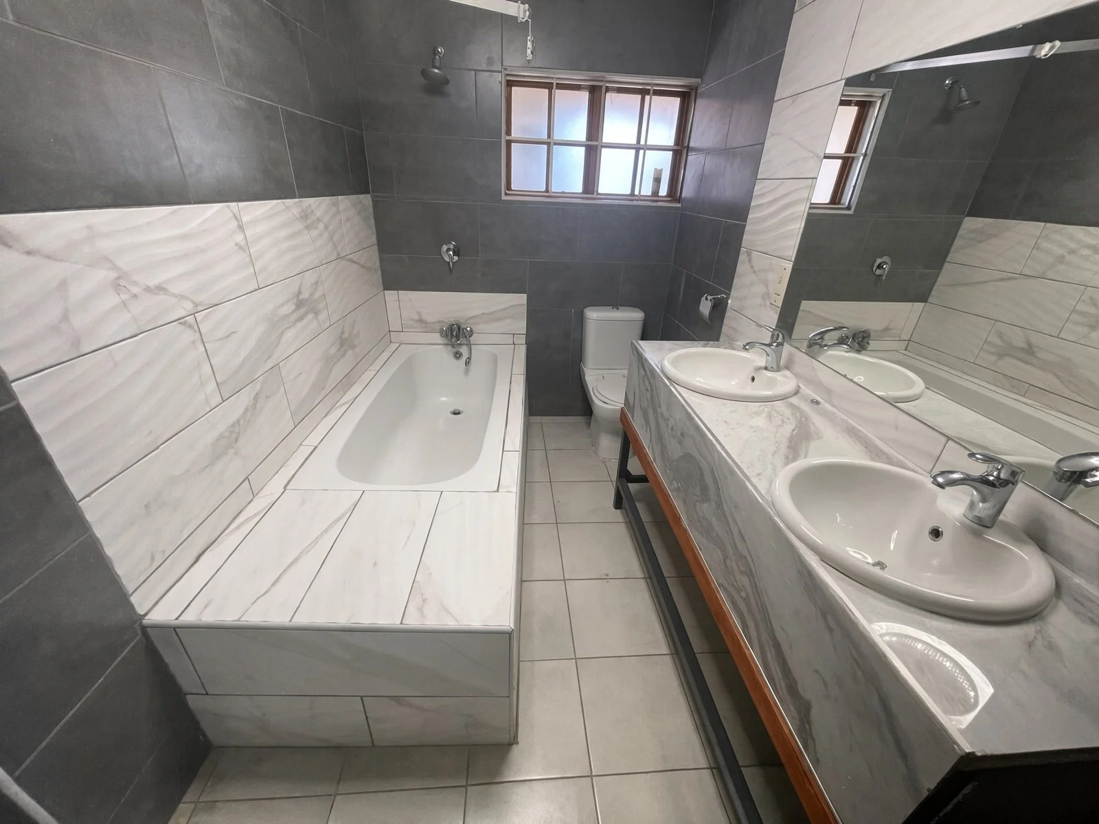 Second ensuite with bathtub and double marble sinks in a 4-bedroom Phakalane rental