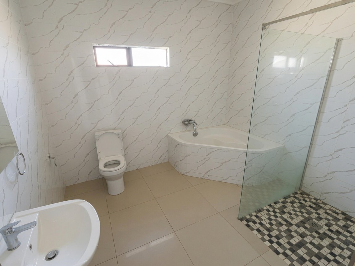 Bathroom with shower and bathtub at an affordable family home with a pool in Tlokweng for rent.