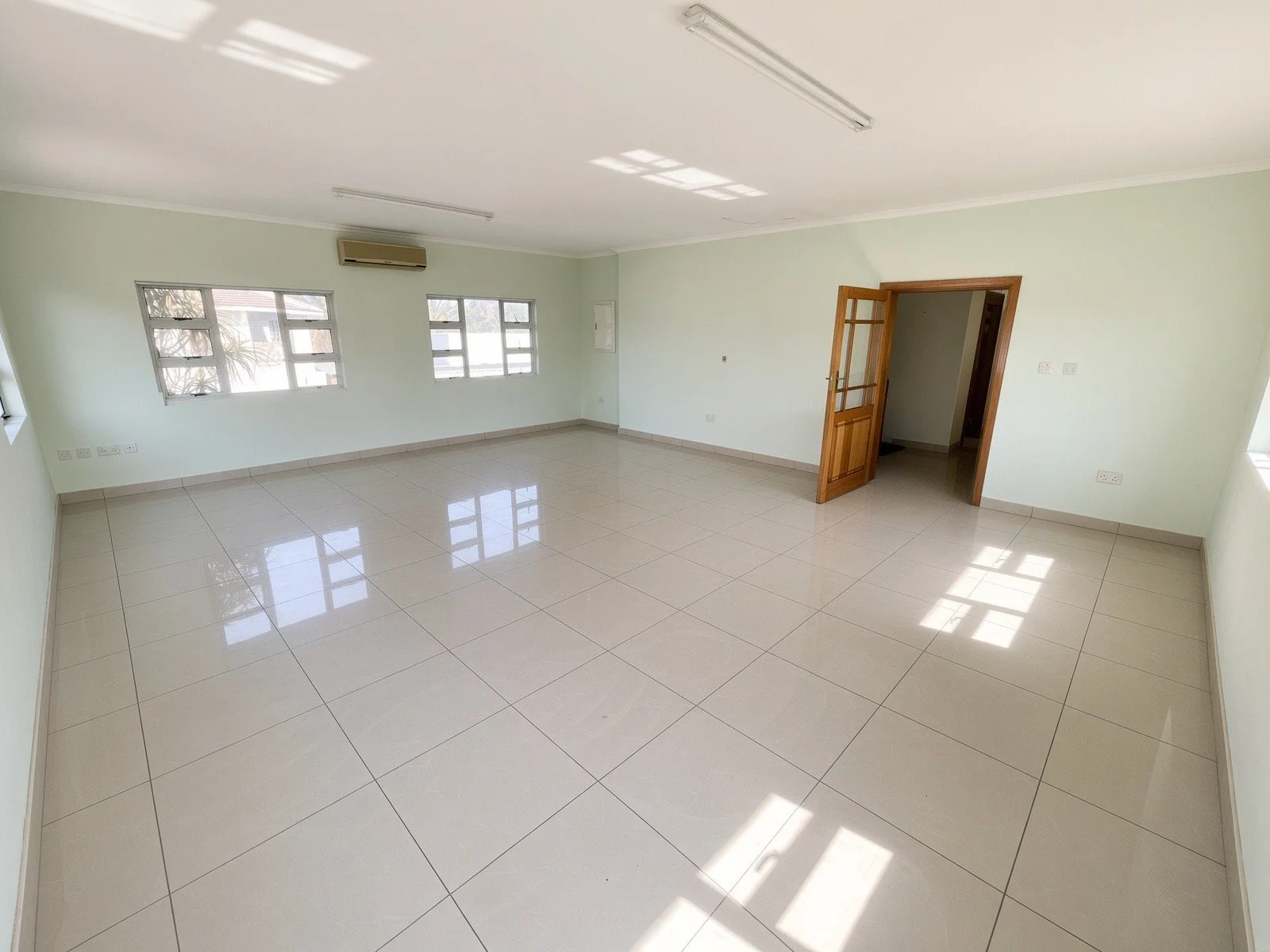 Air-conditioned double-volume lounge with wooden ceiling and large windows in the 4-bedroom house for rent, Phakalane. Nestgeeks.