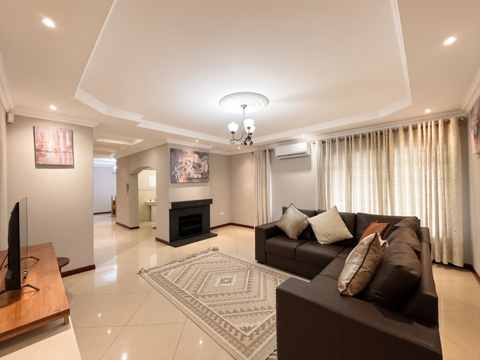 Spacious lounge with fireplace, dining area beyond and air conditioning in the fully furnished 5-bedroom house for rent in Phakalane. Nestgeeks listing.
