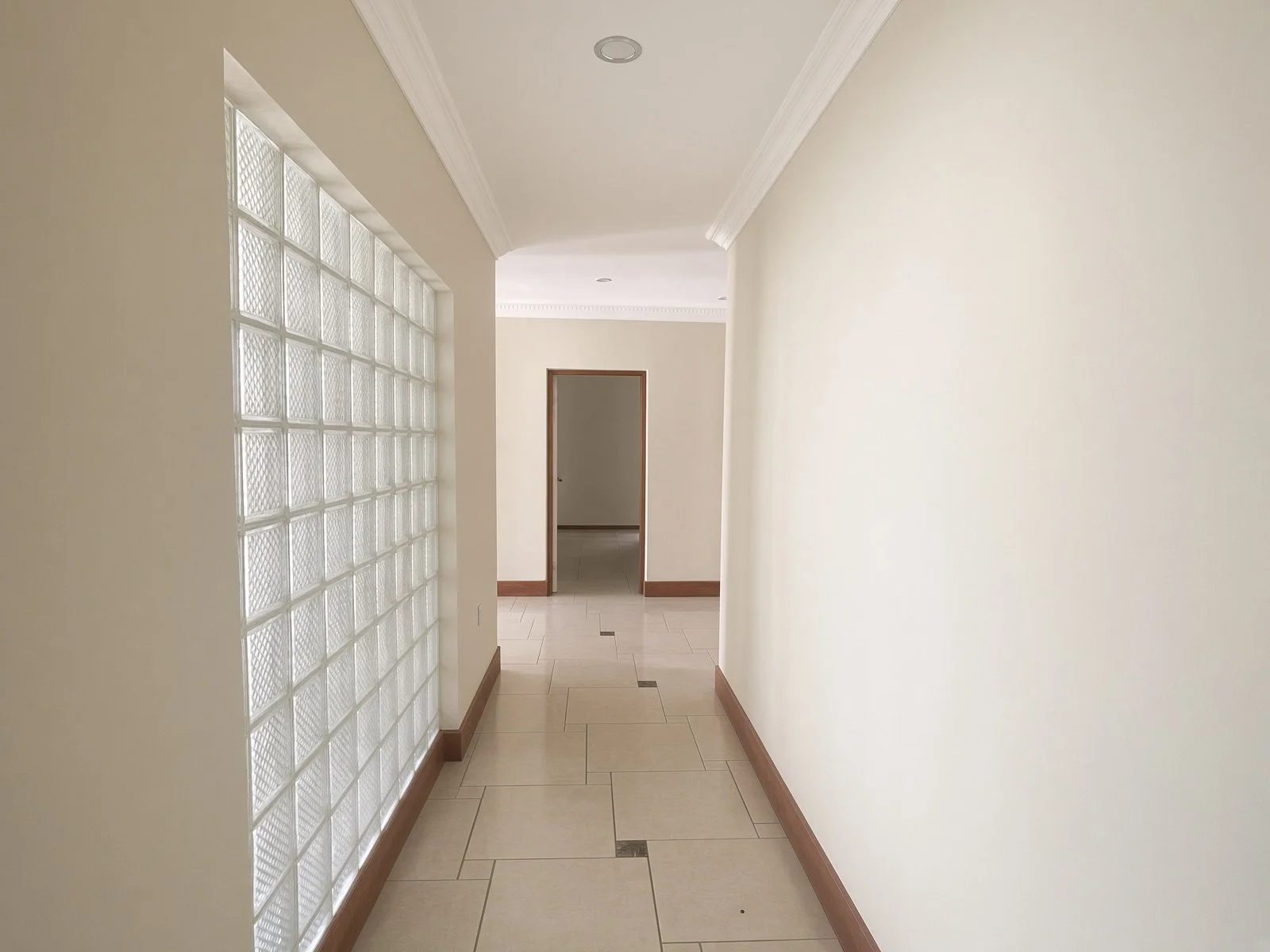 Tiled hallway with glass-block window in a 4-bedroom house for rent in Phakalane