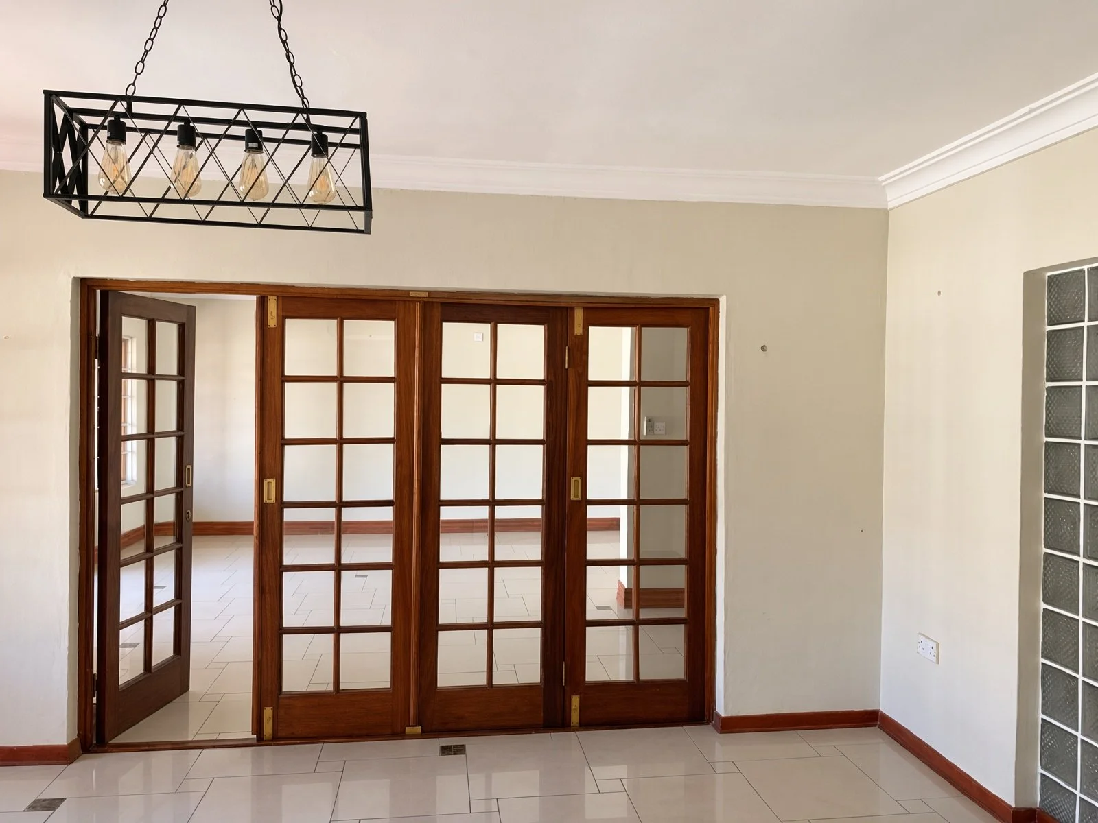 Wooden French doors with black pendant light in a 4-bedroom Phakalane rental