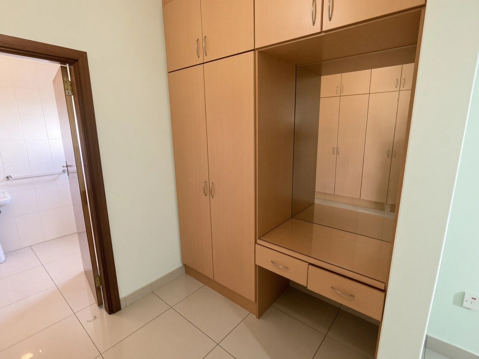 Fitted wardrobe with dressing table and mirror next to ensuite in the 4-bedroom house for rent, Phakalane. Nestgeeks listing.