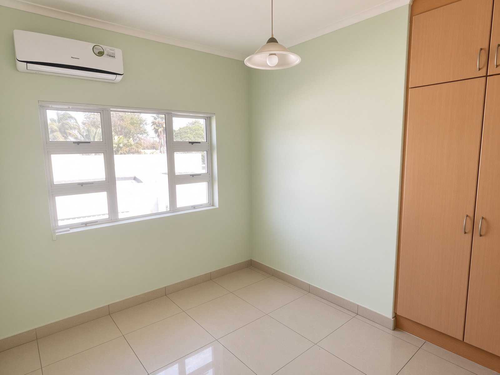 Air-conditioned bedroom with fitted wardrobe and window in the 4-bedroom rental property, gated estate Phakalane. Nestgeeks.