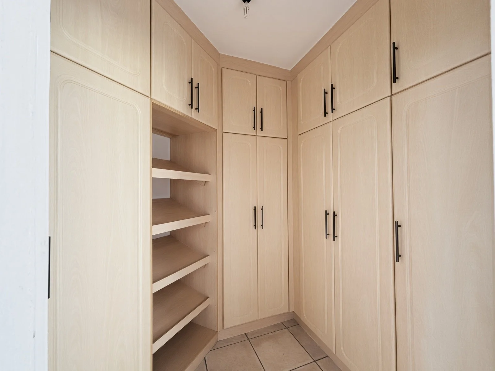 Built-in walk-in wardrobe with light wood finish in a house for sale in Phakalane Golf Estate