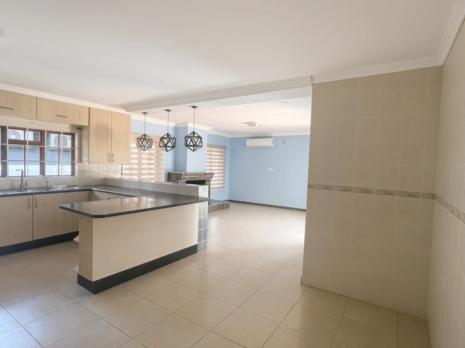Tiled living area with wooden skirting, chandelier and sliding door to the patio, Phakalane rental