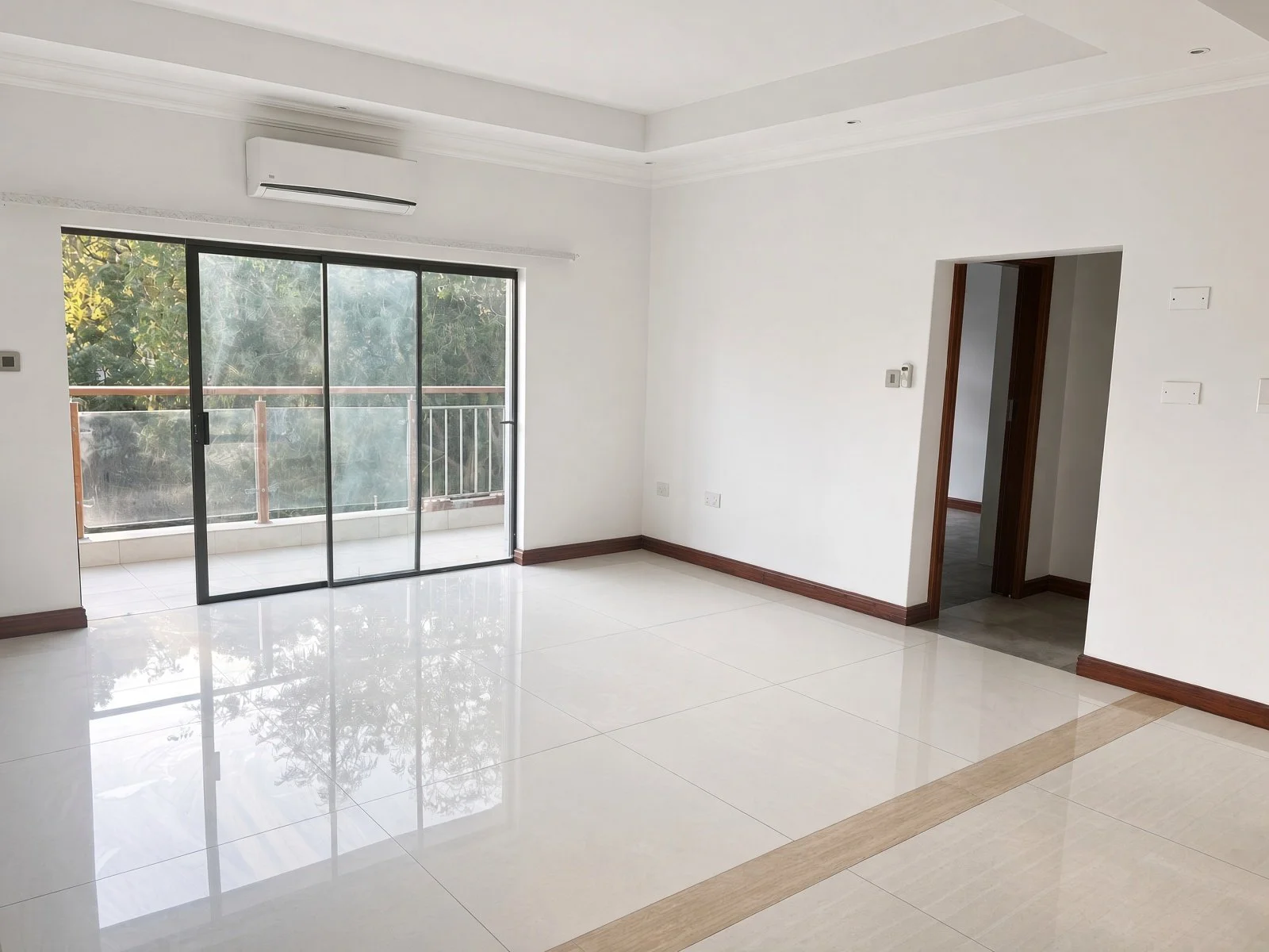 Open-plan living room with polished porcelain tiles and sliding doors to a balcony, apartment for rent in Extension 11 Gaborone