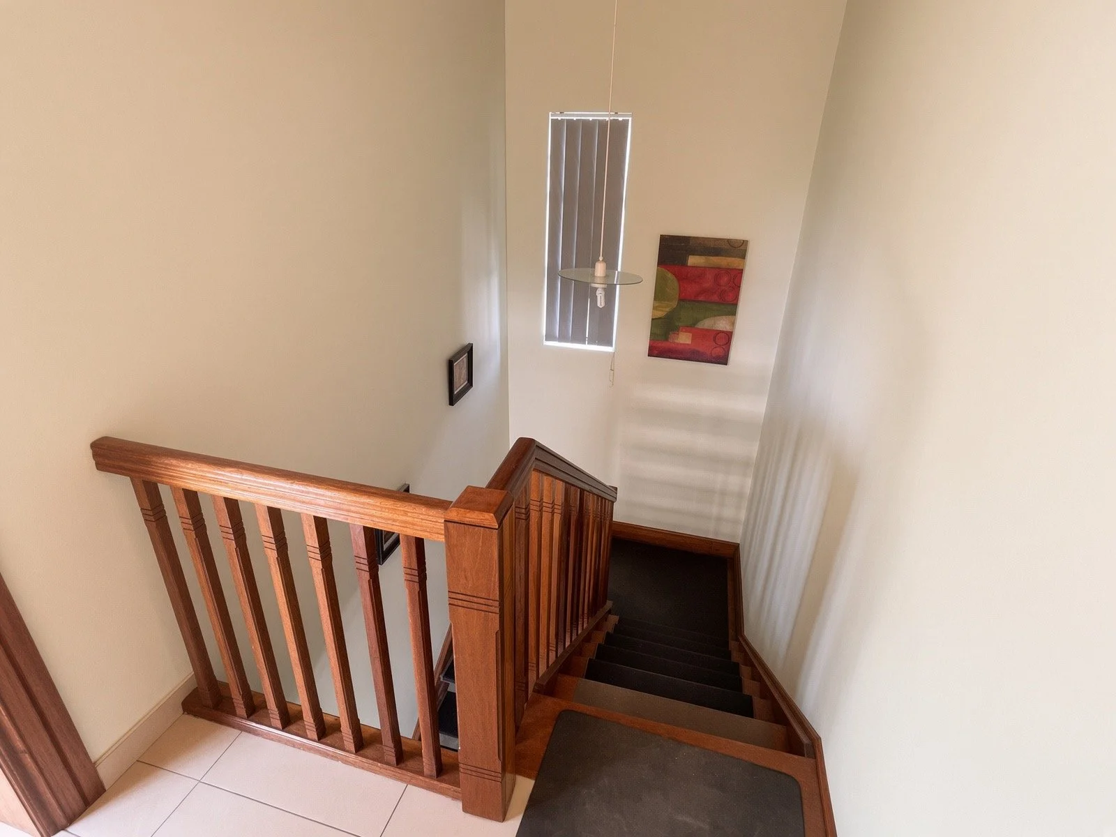 Wooden staircase with railing leading to the upper level of the 4-bedroom house for rent in Phakalane gated estate. Nestgeeks.