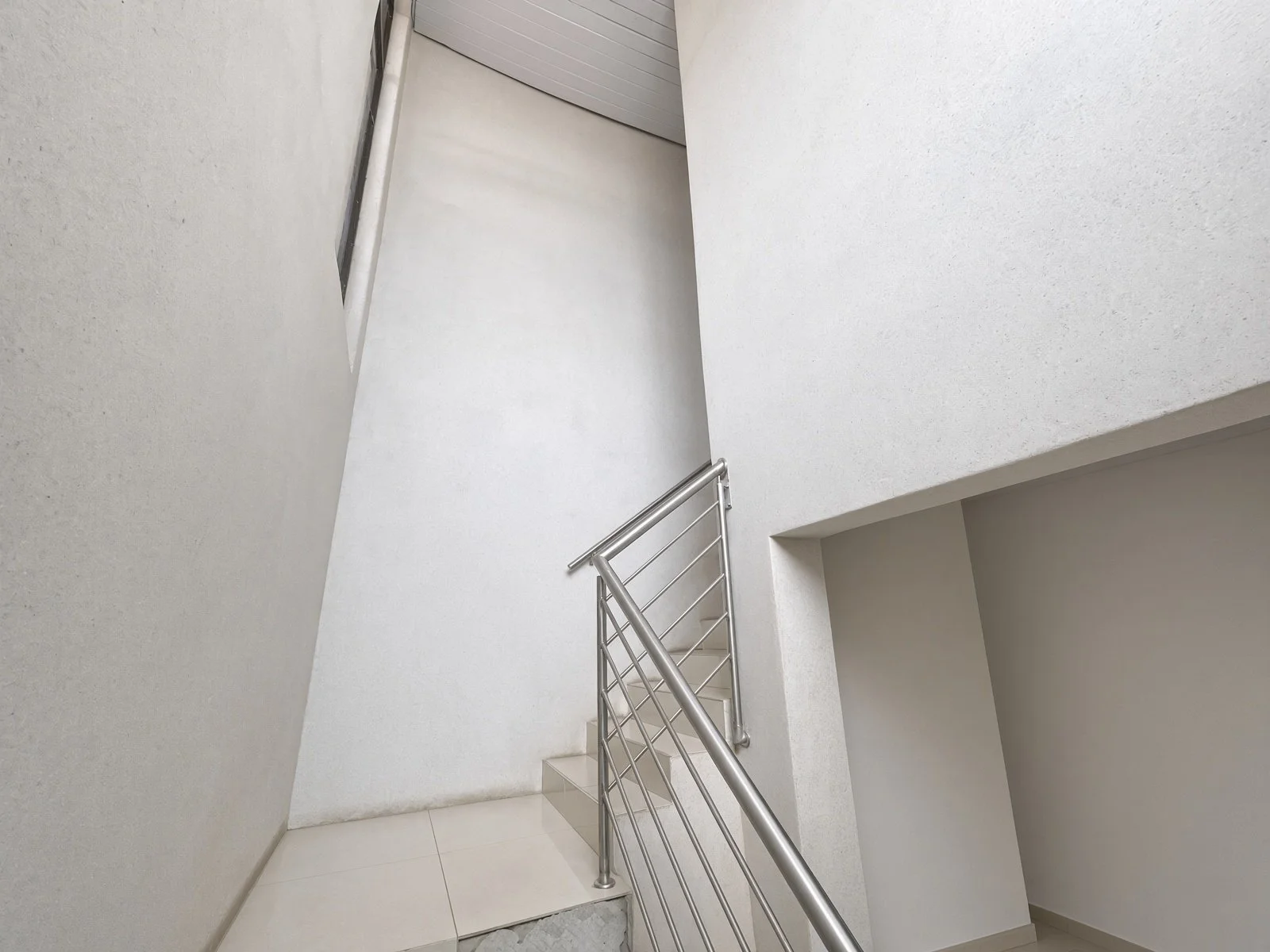 Internal staircase with stainless steel balustrade in a double-storey house for sale in Gaborone