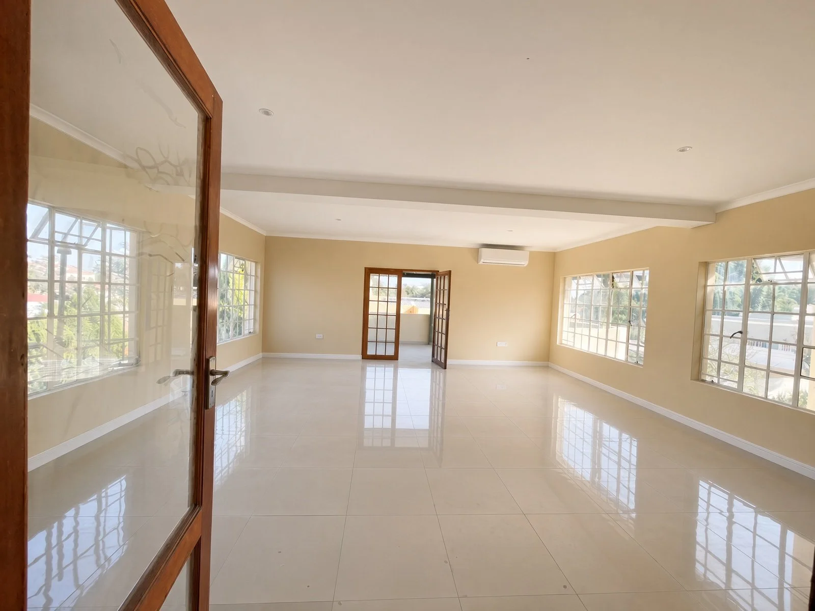 Bright entertainment room with air conditioning and garden-facing windows in a Block 9 Gaborone rental