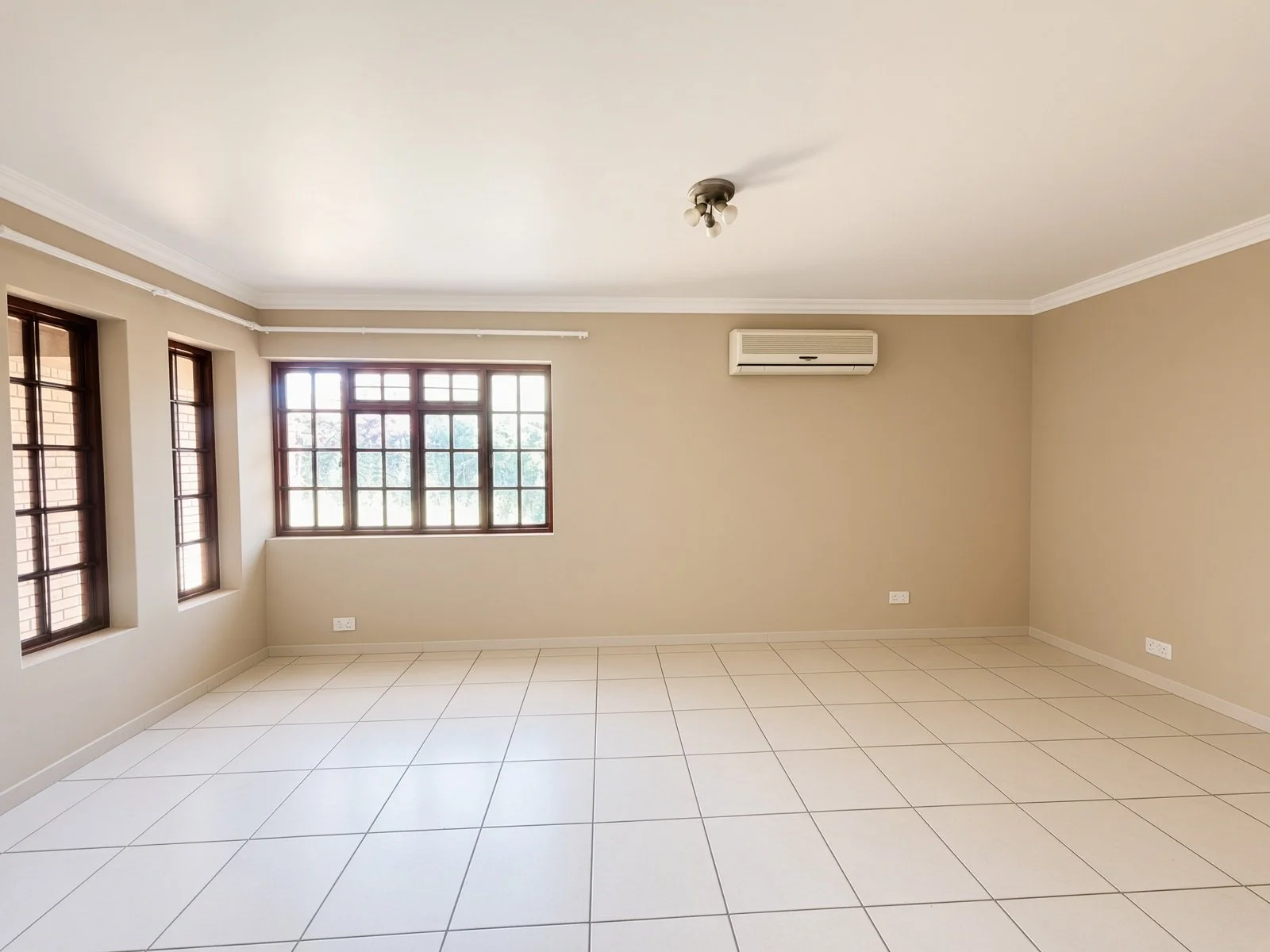 Bright room with wooden windows and wall-mounted aircon in a Phakalane house for sale