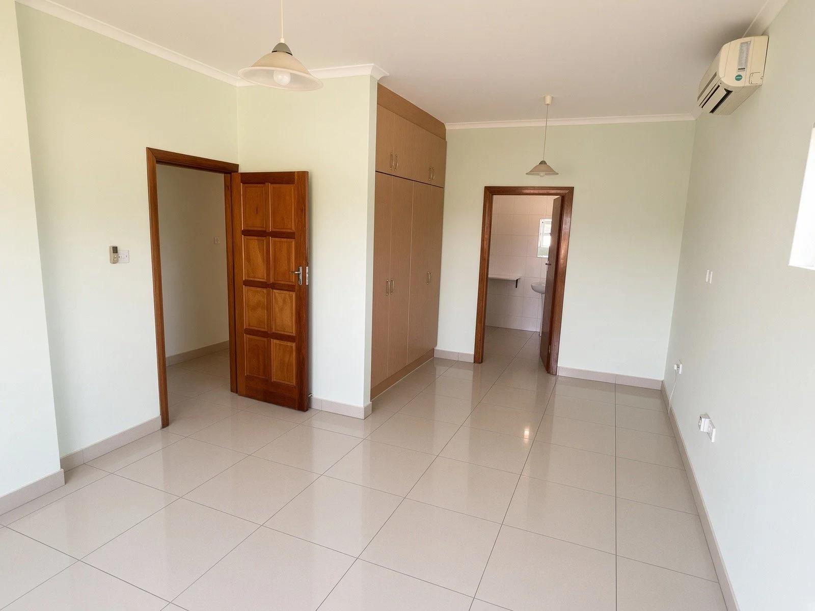 Spacious bedroom with built-in wardrobes and ensuite bathroom access in the 4-bedroom rental home, gated estate Phakalane. Nestgeeks listing