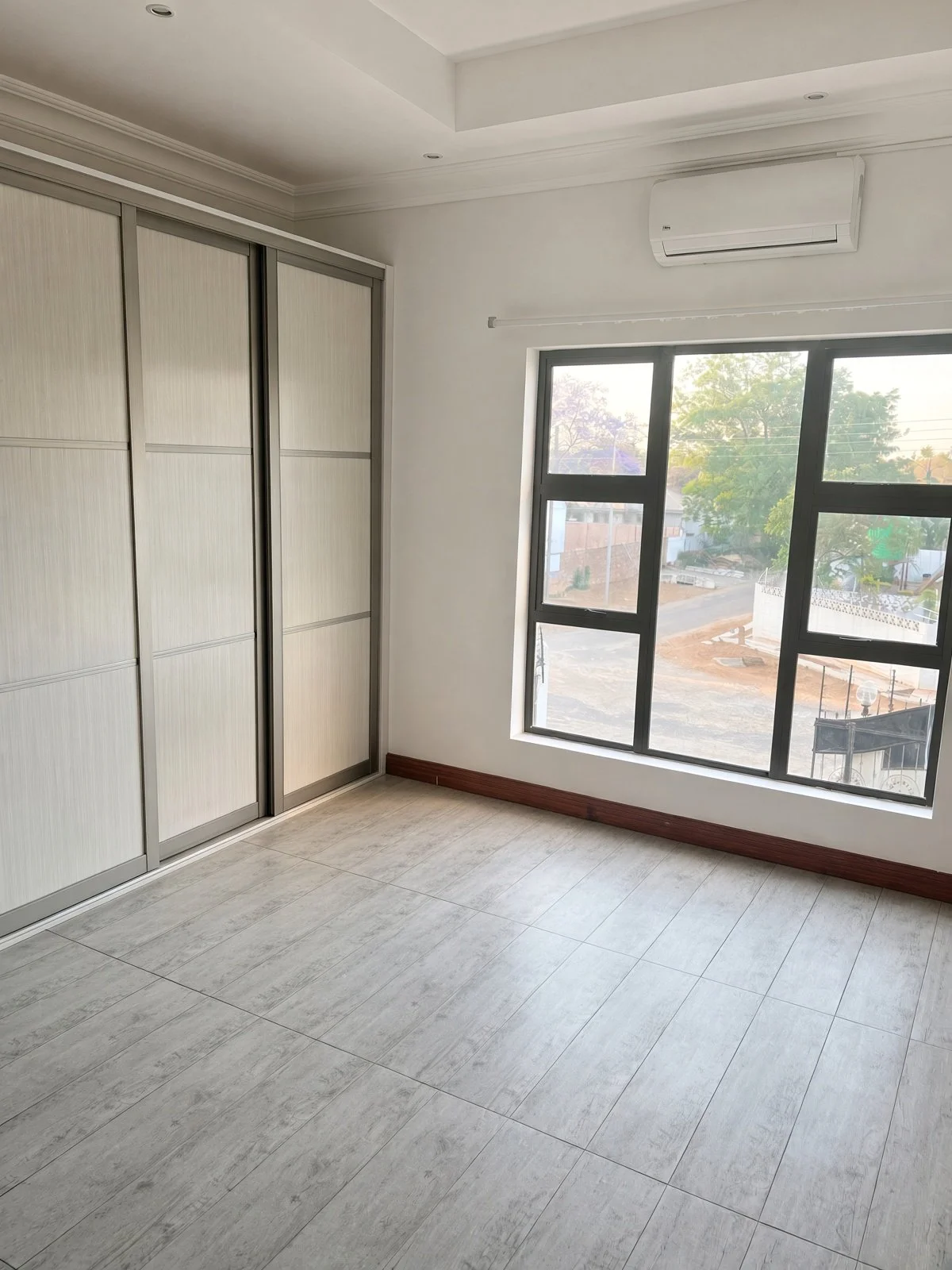Bedroom with built-in sliding wardrobes, air conditioning and large window, 2-bedroom apartment Extension 11 Gaborone