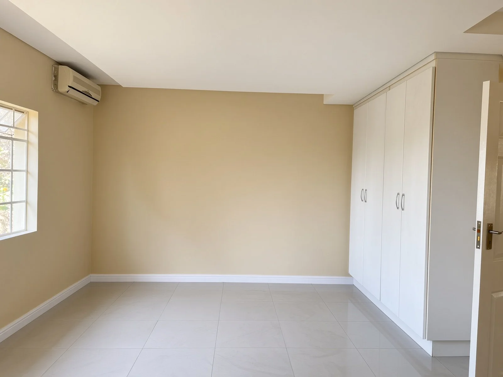 Bedroom with wall of built-in cupboards and air conditioning in a 5-bedroom house for rent in Block 9