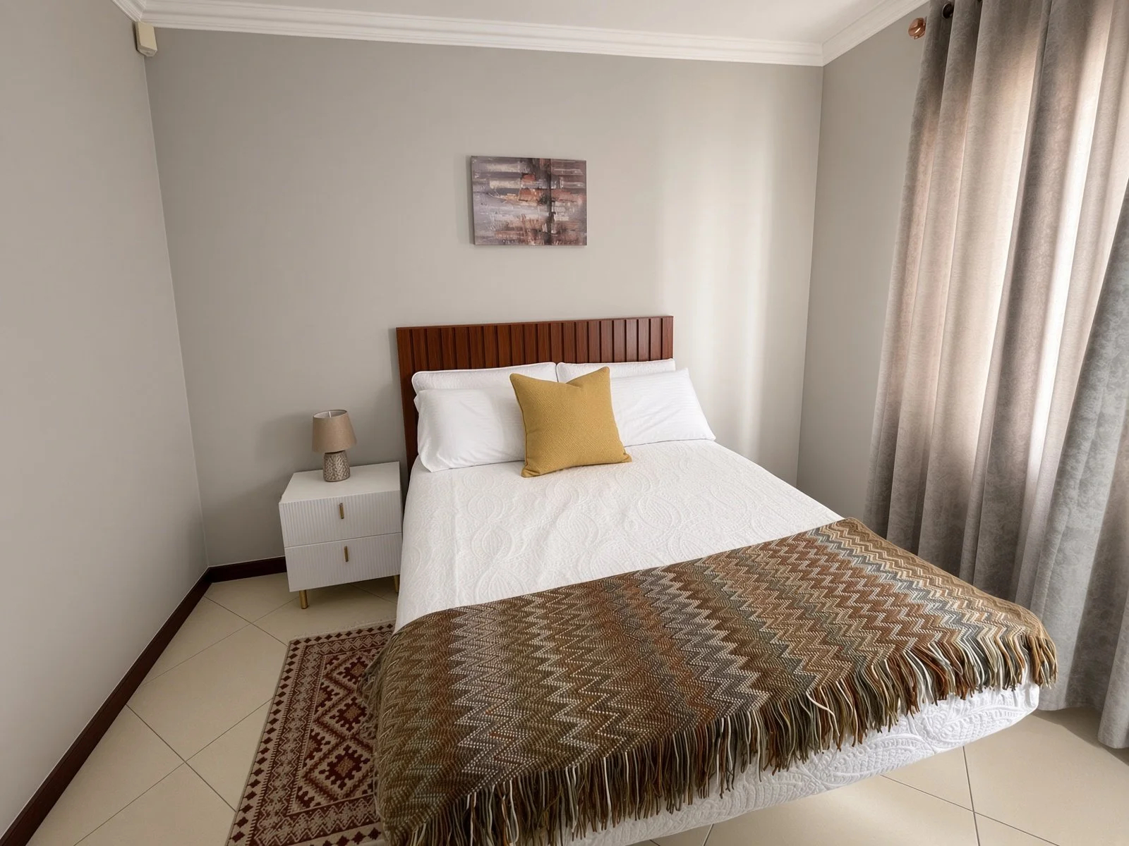 Furnished bedroom with wooden slat headboard, mustard accent and air conditioning in the 5-bedroom Phakalane rental home. Nestgeeks.