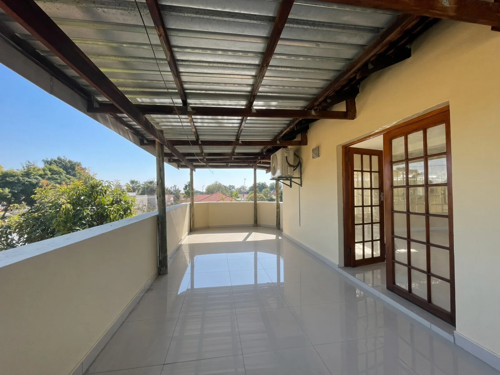 Covered balcony with tiled floor and garden views at a family house for rent in Block 9 Gaborone