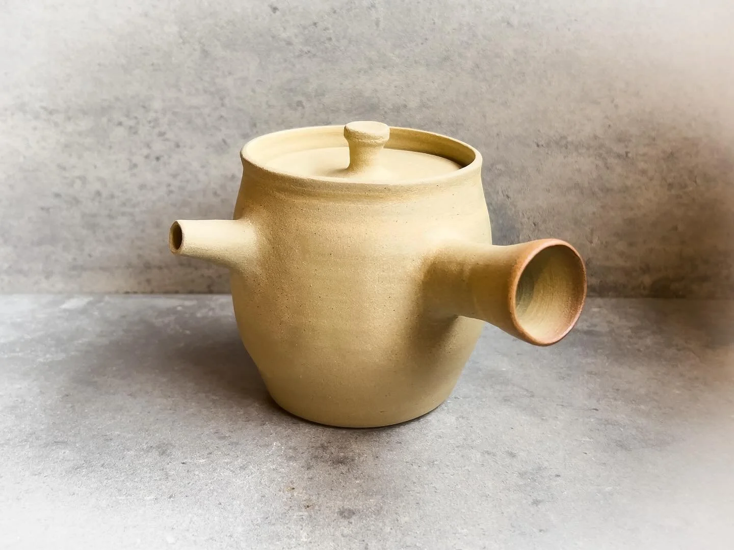 A recent teapot made from French Puisaye clay. This small style of tea pot is usually left unglazed (as this one is) and is used to brew small cups of fine teas. The first picture (the teapot is light in colour) is the teapot once fired to 1270c. The