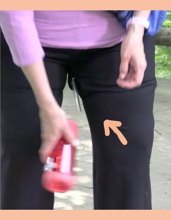 woman-pees-through-Extension-tube-that-protrudes-through-zipper-of-Thighfly-pants-using-pee-funnel-GOthrough