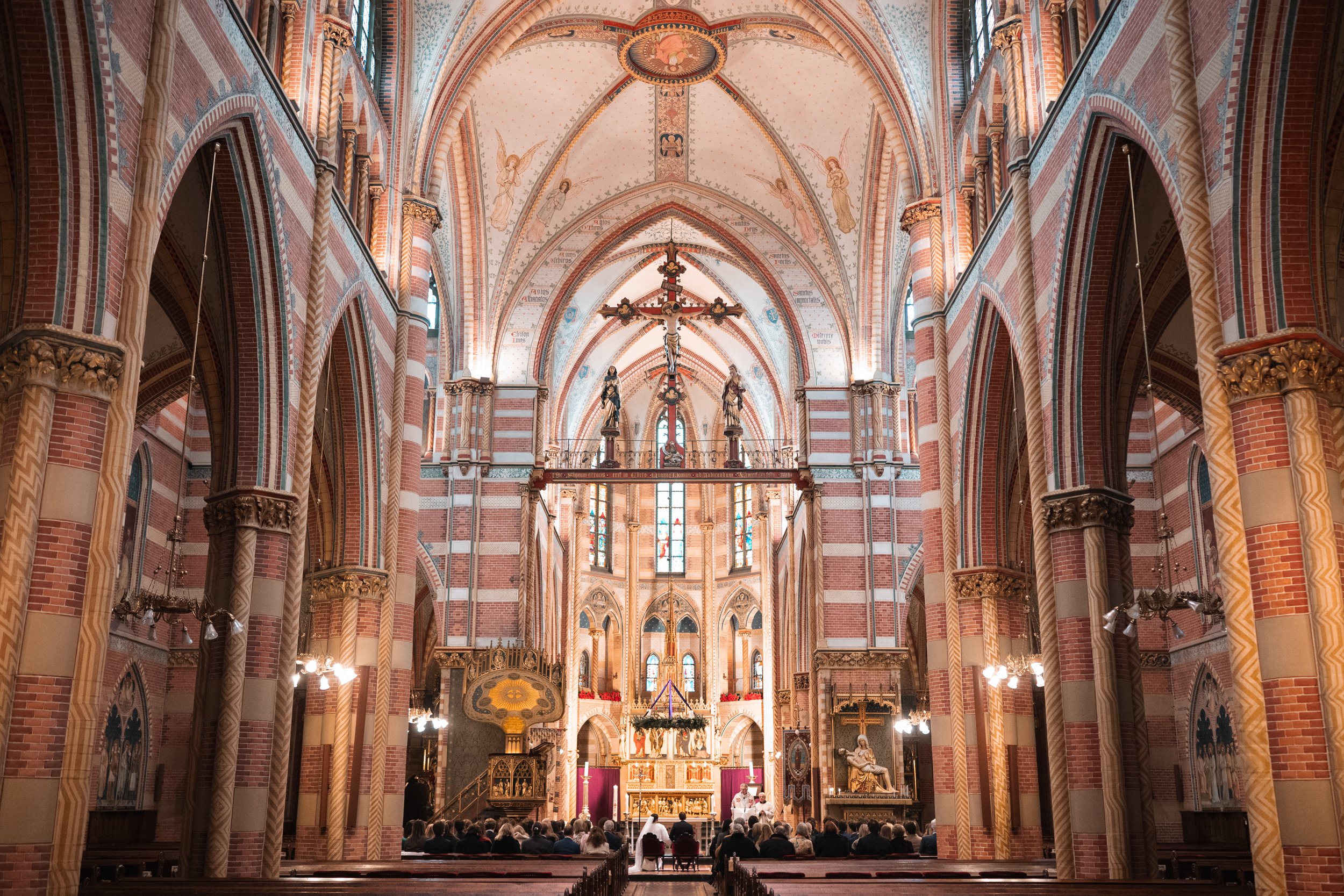 Interior of a large, ornate church with high vaulted ceilings, stained glass windows, and a congregation seated in the pews during a service.