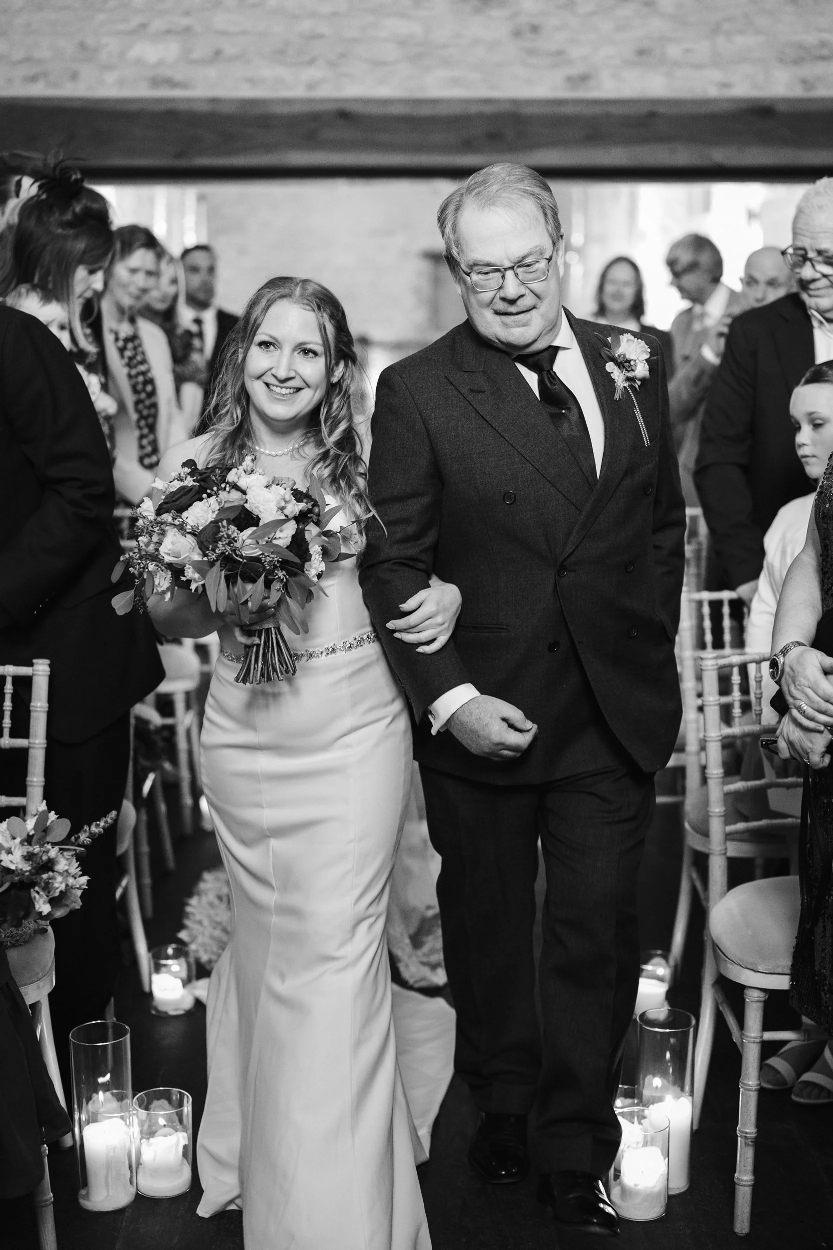 A bride walking down the aisle with her father during a wedding ceremony.