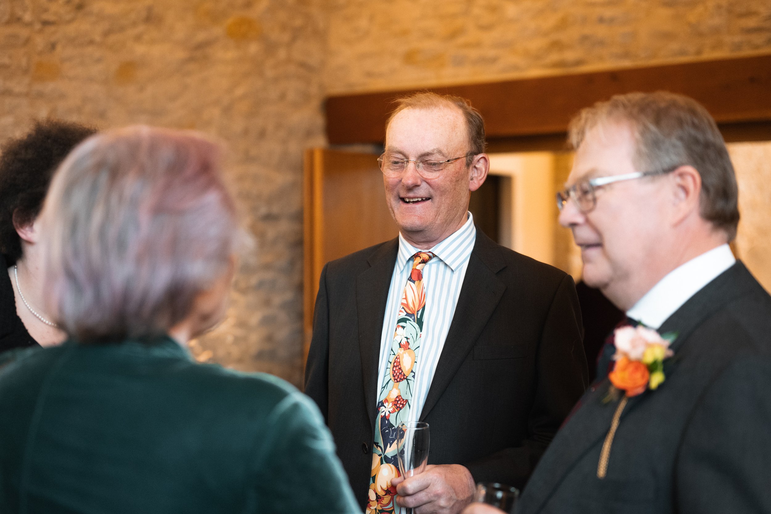 People in formal attire engaging in conversation at a social event or gathering.